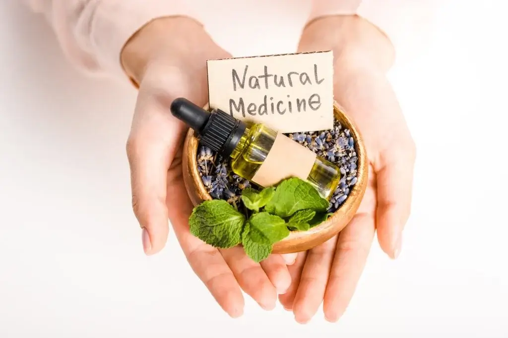 cropped image of woman holding bowl with essential oil and natural medicine sign isolated on white 1024x683 1